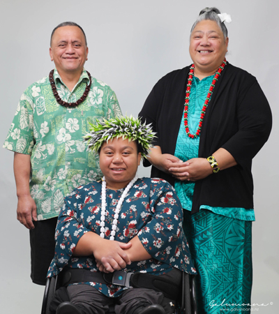 Young teenage girl on her wheelchair with her parents behind her side by side